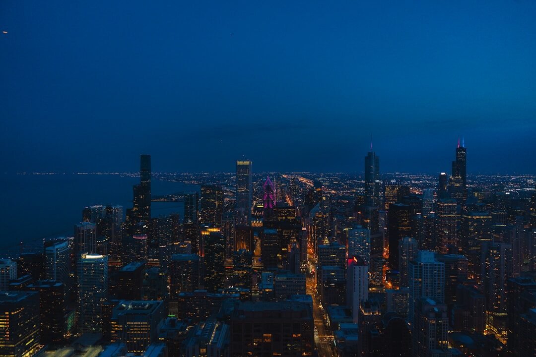 City skyline illuminated at night with a dark blue sky.