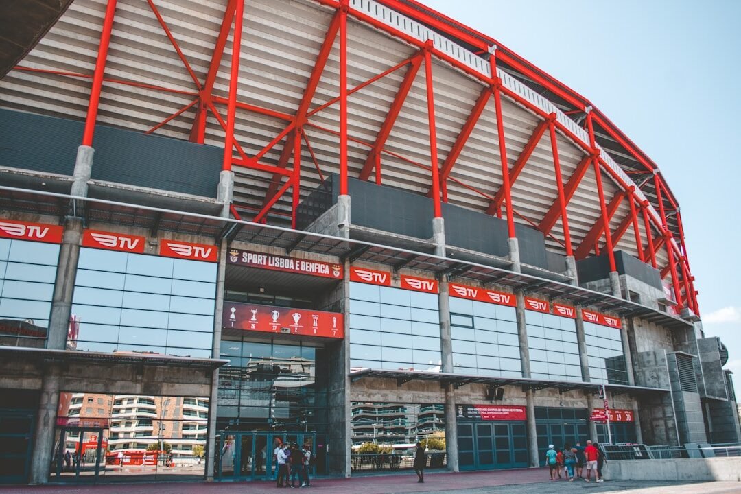 a red and white stadium building with people standing outside