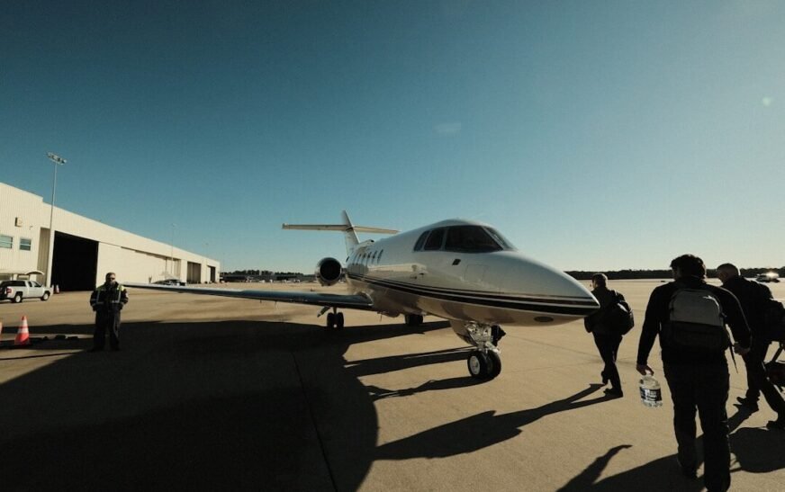 a group of people walking towards a small plane