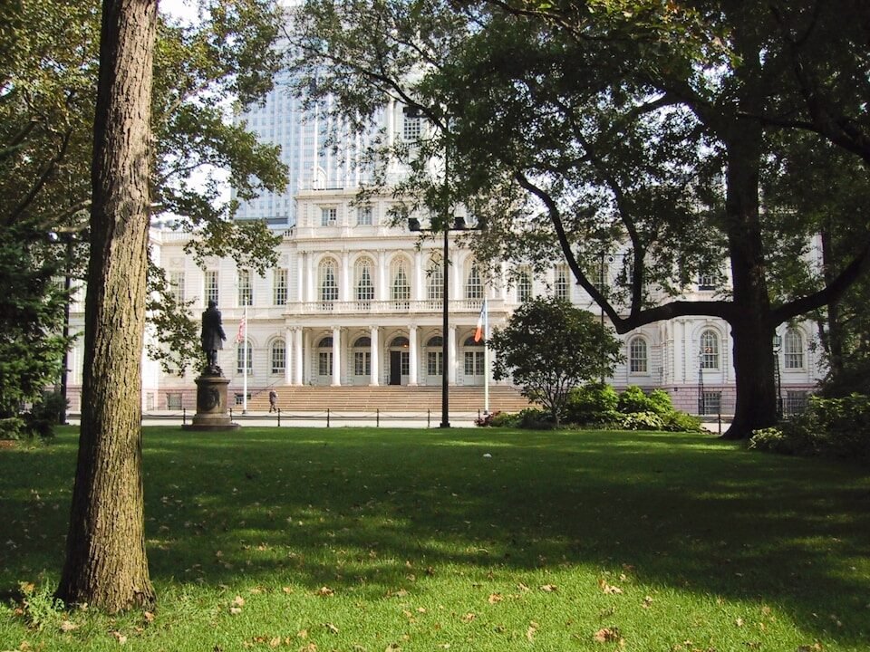 A large white building surrounded by trees and grass
