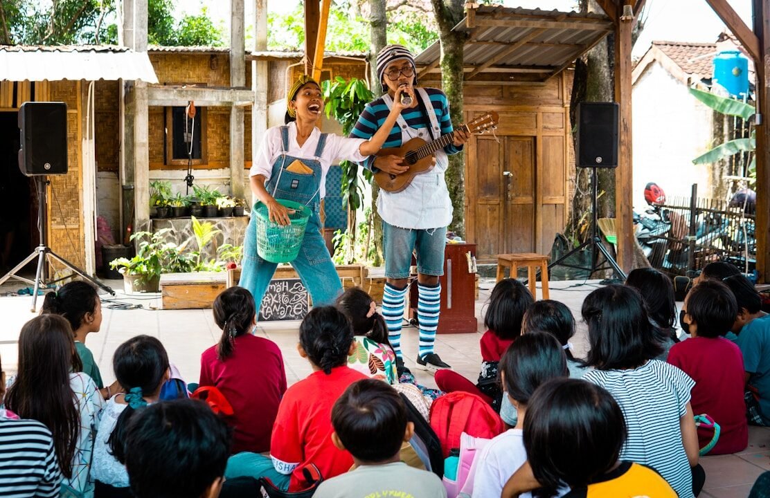 Performers entertain children with music and laughter.