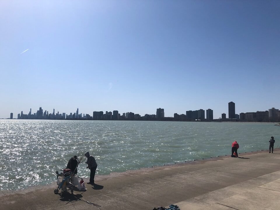 a group of people standing next to a body of water