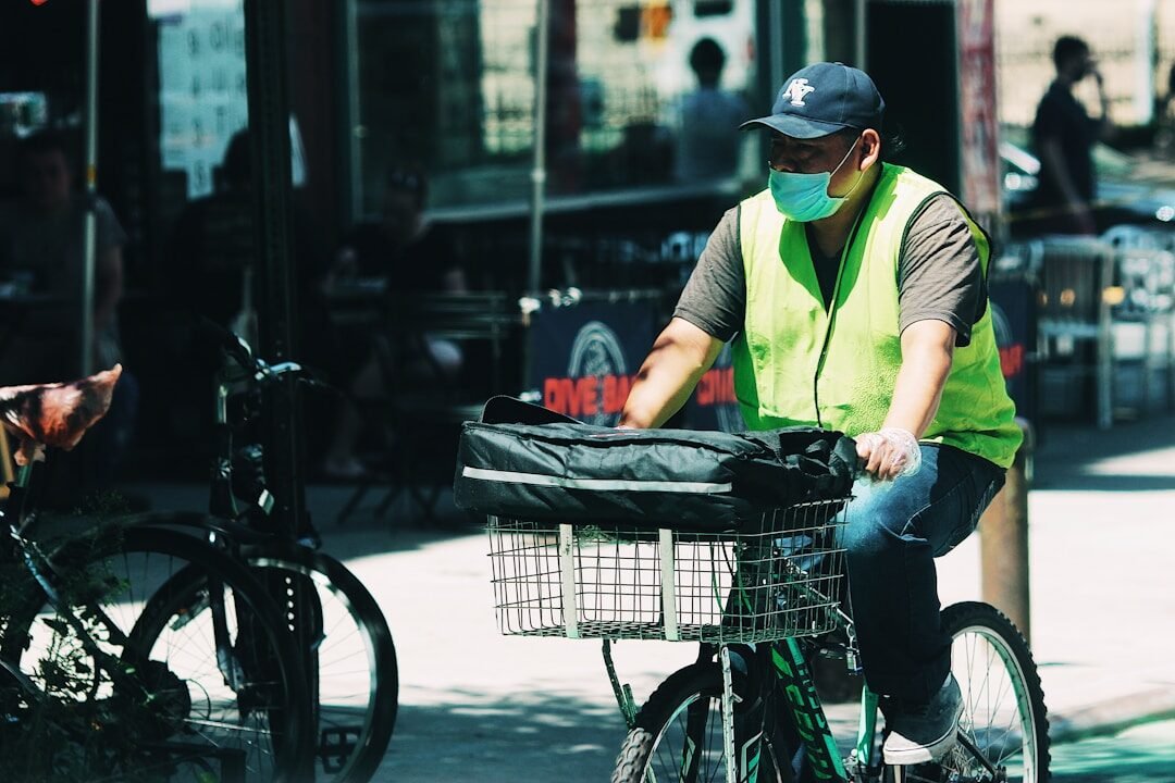 man in green t-shirt and blue denim jeans holding a basket of fruits