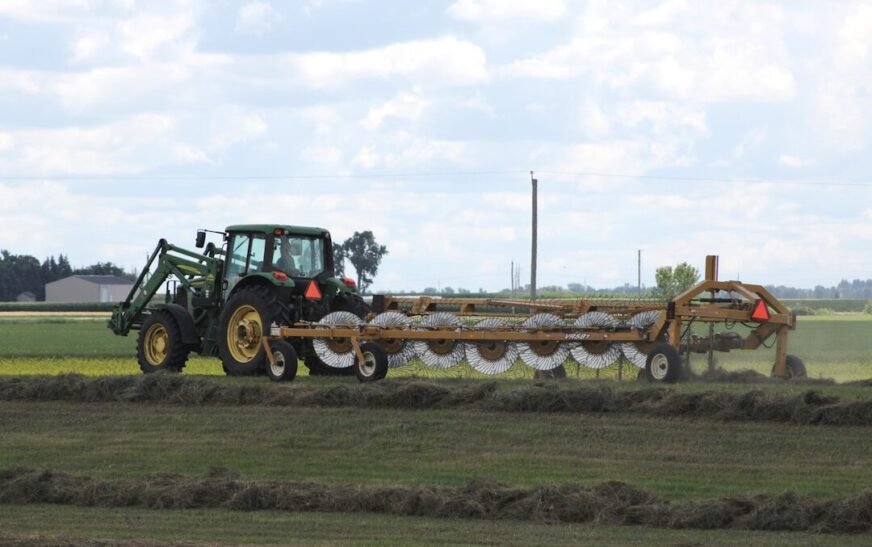 green tractor on green grass field during daytime