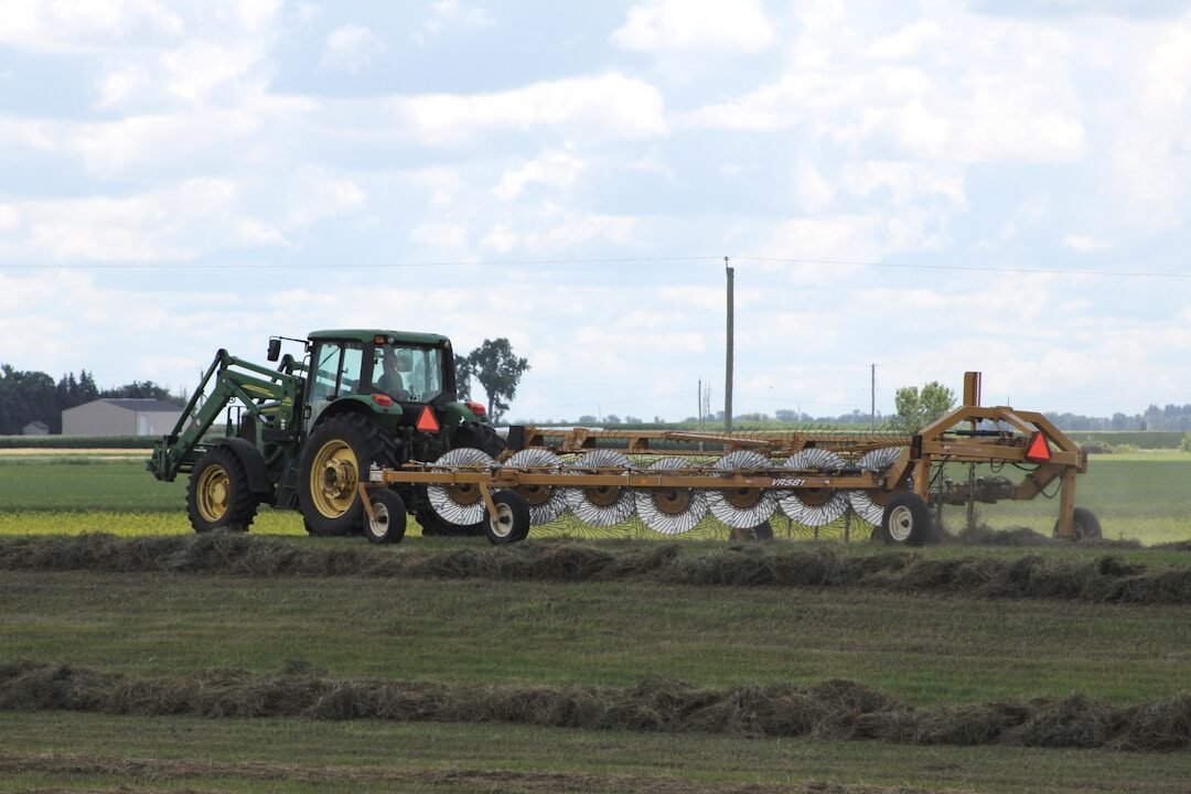 green tractor on green grass field during daytime