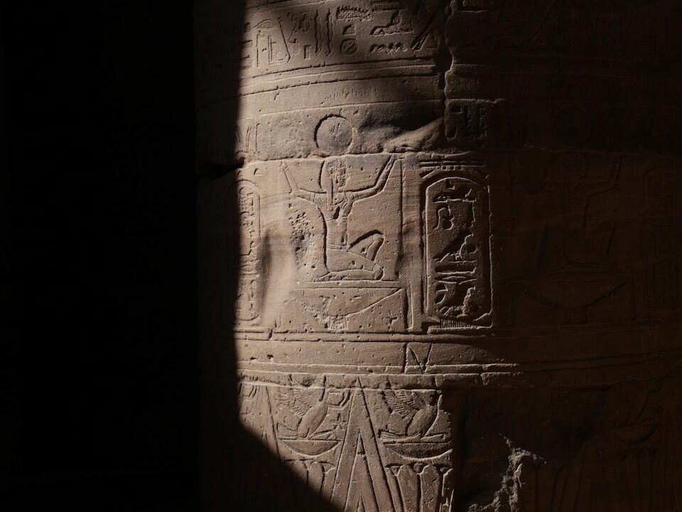 Ancient egyptian hieroglyphs carved on a stone column.