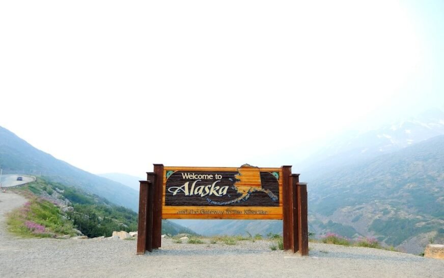 brown wooden signage on gray sand during daytime