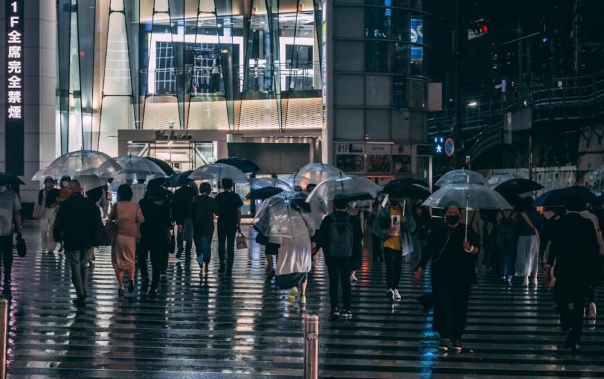 people walking on sidewalk with umbrella during rain