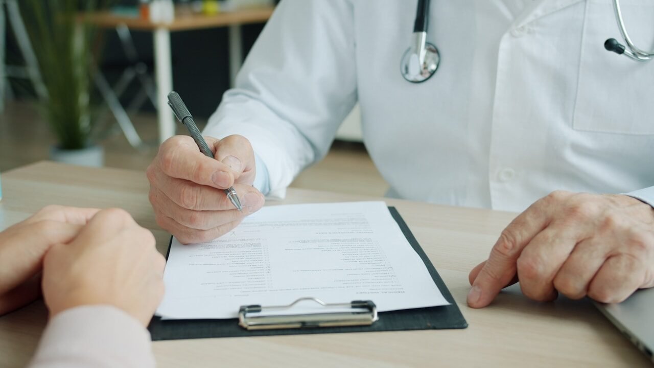 Doctor writing on a patient's chart