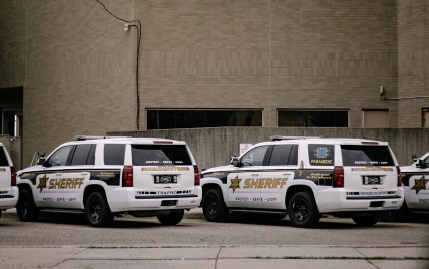 a couple of white cars parked in front of a building