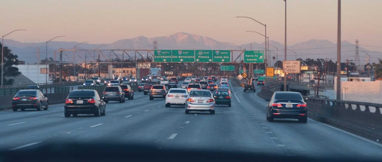 a highway filled with lots of traffic next to mountains