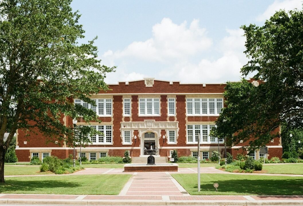 Old brick school building framed by trees