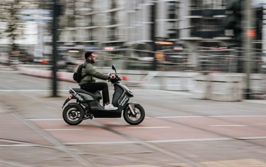 man in green jacket riding motorcycle on road during daytime